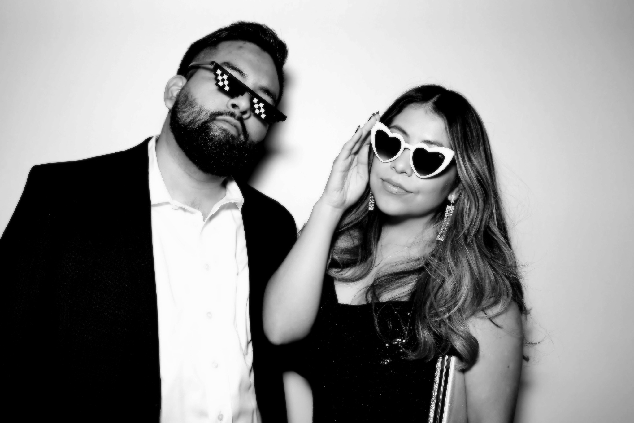 Two guests wearing playful sunglasses in a black and white Beauty portrait
