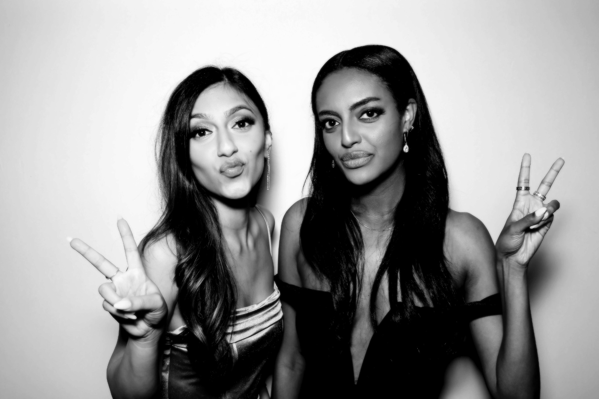 Two friends making peace signs in a black and white Beauty portrait