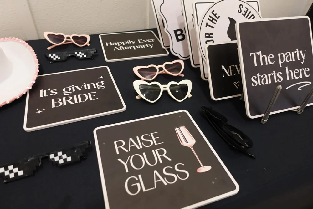 Photo booth prop table with heart glasses and handheld signs