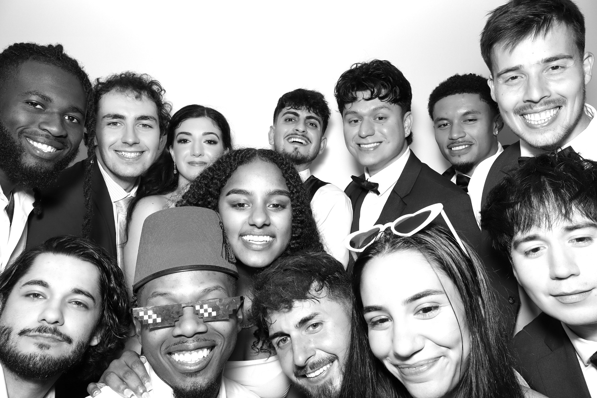 A large group of wedding guests smiling together in a black and white Beauty portrait