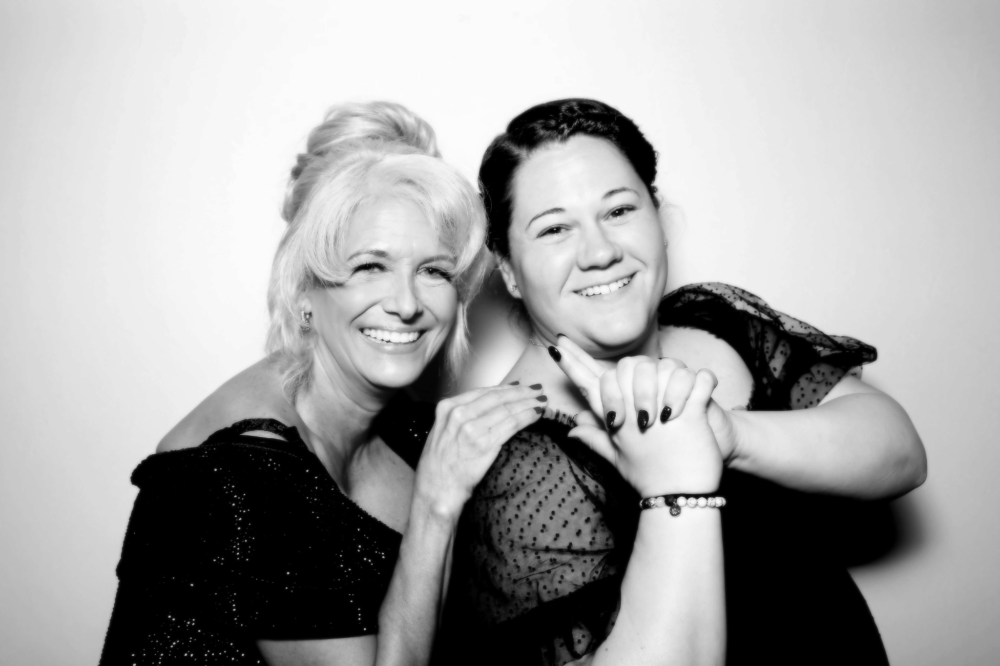 Two women smiling shoulder to shoulder in a black and white Beauty portrait