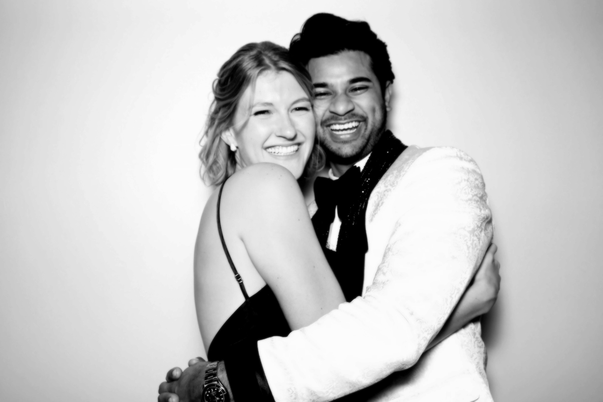 Two guests embracing in a black and white Beauty portrait with a monogram at the upper left
