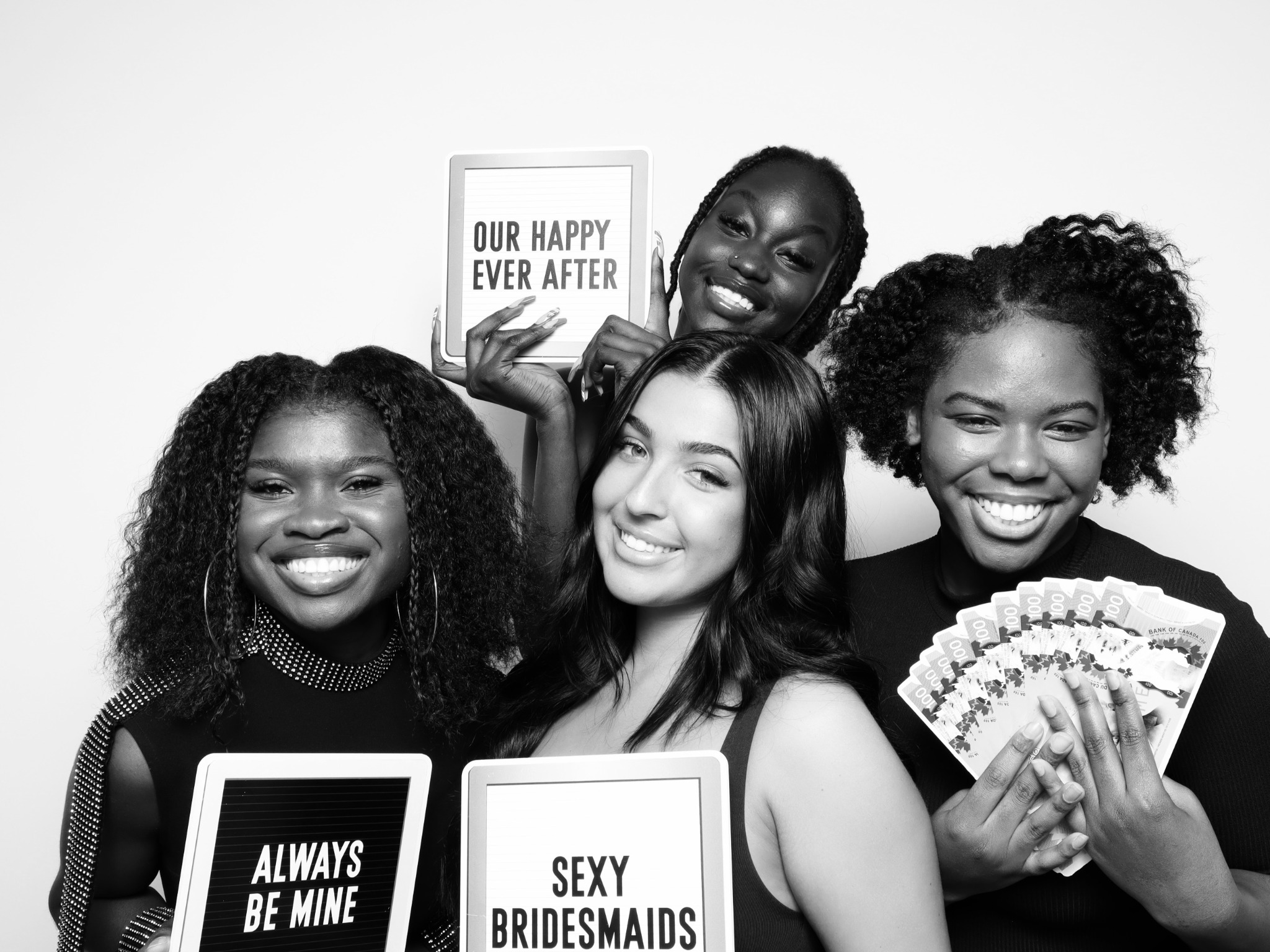 Four guests smiling with wedding celebration signs in a black and white Beauty portrait