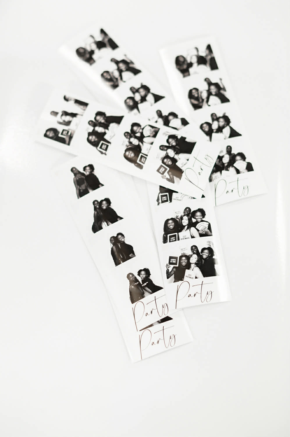 Personalized black and white photo strips arranged on a white surface