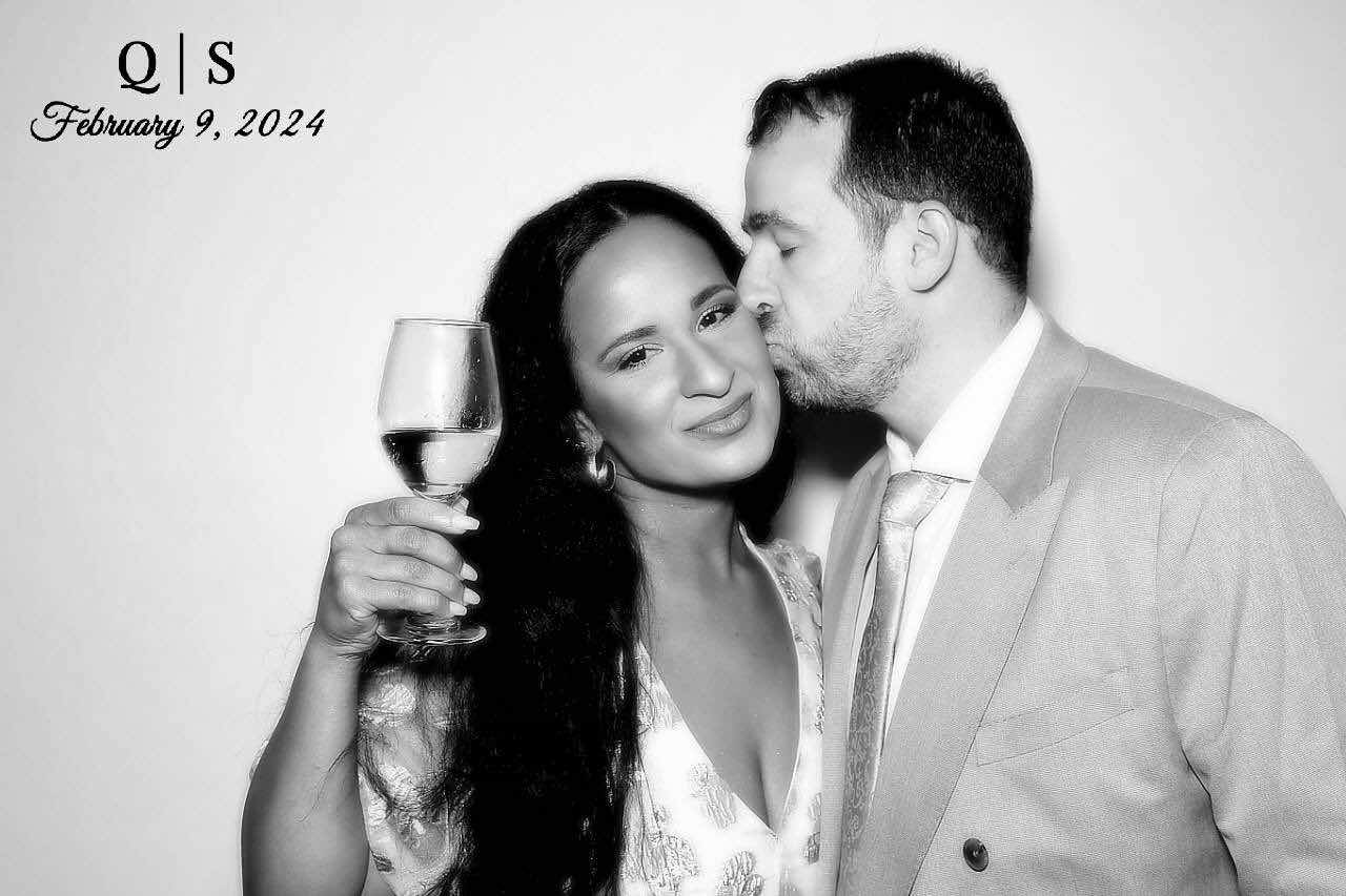 A couple sharing a kiss on the cheek in a personalized black and white portrait