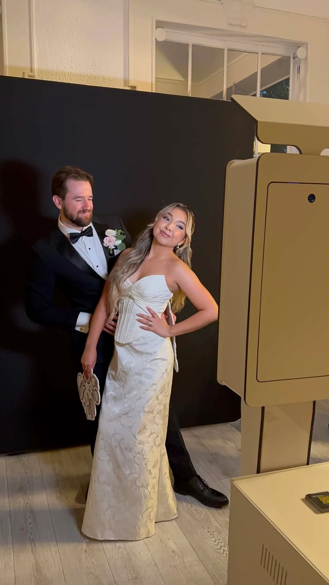 Novios junto a una cabina de fotos durante su boda