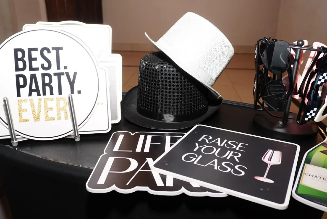 Mesa de props de Photo Booth Houston con letreros de fiesta, sombreros y lentes