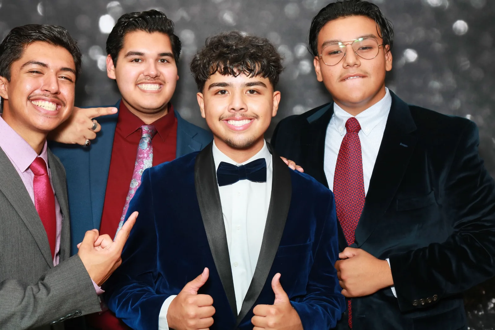 Cuatro invitados posando juntos para una foto divertida en una celebración formal