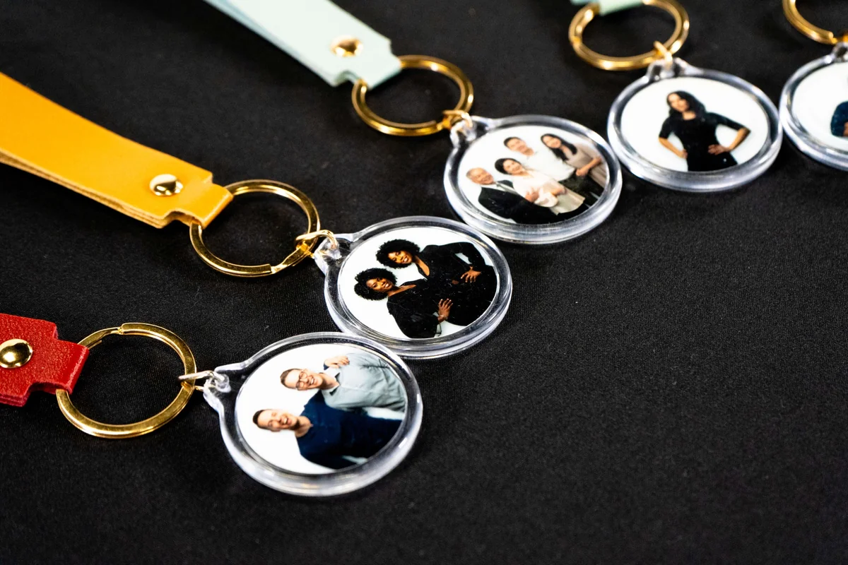Llaveros con retratos y broches dorados sobre una mesa